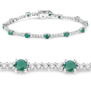 May include: A silver tennis bracelet featuring emerald green gemstones and small clear diamonds.
