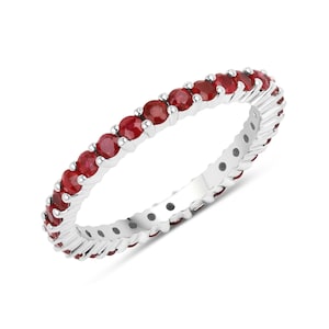 Puede incluir: Un anillo de eternidad de plata con una fila de rubíes rojos.