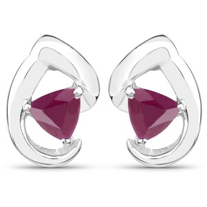 May include: A pair of silver earrings with a triangular ruby gemstone in each earring. The earrings have a simple, modern design.