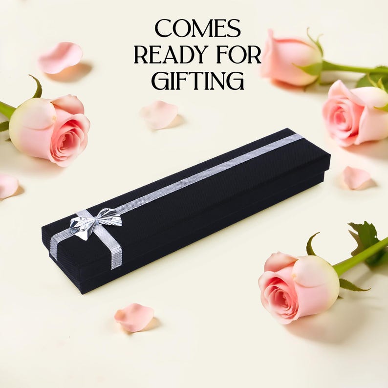May include: A black velvet gift box with a silver ribbon and bow. The box is ready for gifting and has the text "COMES READY FOR GIFTING" printed on a white background.