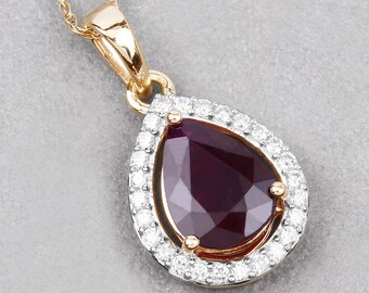 May include: A gold pendant necklace featuring a pear-shaped, faceted, deep red gemstone, surrounded by a halo of small, round, clear gemstones. The pendant hangs from a delicate gold chain.
