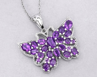 May include: A silver butterfly pendant necklace with purple amethyst gemstones. The butterfly is detailed with intricate wings and a delicate chain.