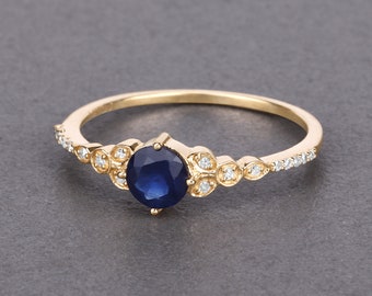 May include: A gold ring with a blue sapphire gemstone and small diamonds set in a delicate floral design.