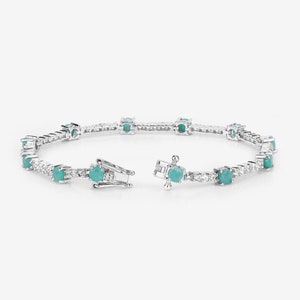 May include: A silver tennis bracelet featuring turquoise gemstones and clear cubic zirconia stones.