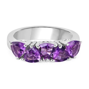 May include: A silver ring with four amethyst gemstones set in a triangular shape. The ring is made of sterling silver and features a polished finish.