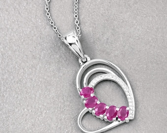 May include: A silver heart-shaped pendant necklace with a double heart design. The pendant is adorned with five pink oval-shaped gemstones and a row of smaller white gemstones.