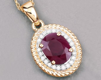 May include: A gold pendant necklace featuring an oval, deep red ruby gemstone. The ruby is surrounded by a halo of small, clear gemstones and a twisted gold rope design. The necklace chain is a delicate gold color.