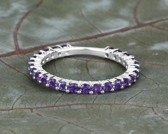 May include: A silver band ring with a row of small, round, purple amethyst gemstones.