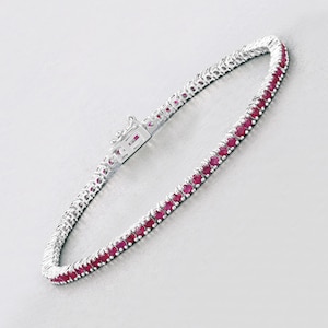 Puede incluir: Un brazalete de tenis de plata con una fila de piedras de rubí rojas.