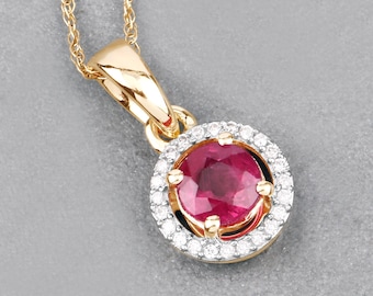 May include: A gold pendant necklace featuring a round, deep red gemstone encircled by a halo of small, sparkling diamonds. The pendant is suspended from a delicate gold chain, creating an elegant and eye-catching piece of jewelry.