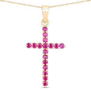 Puede incluir: Un colgante de cruz de oro con una cadena, engastado con pequeñas piedras de rubí rosa.