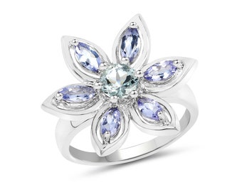 May include: A silver ring with a flower design featuring a light blue center stone and six smaller light blue stones around it.
