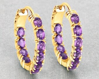 May include: A pair of gold hoop earrings with a row of purple amethyst gemstones around the hoop.
