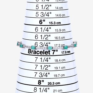 May include: A silver bracelet with green gemstones and white diamonds. The bracelet is measured on a sizing chart and is 7 inches in length.