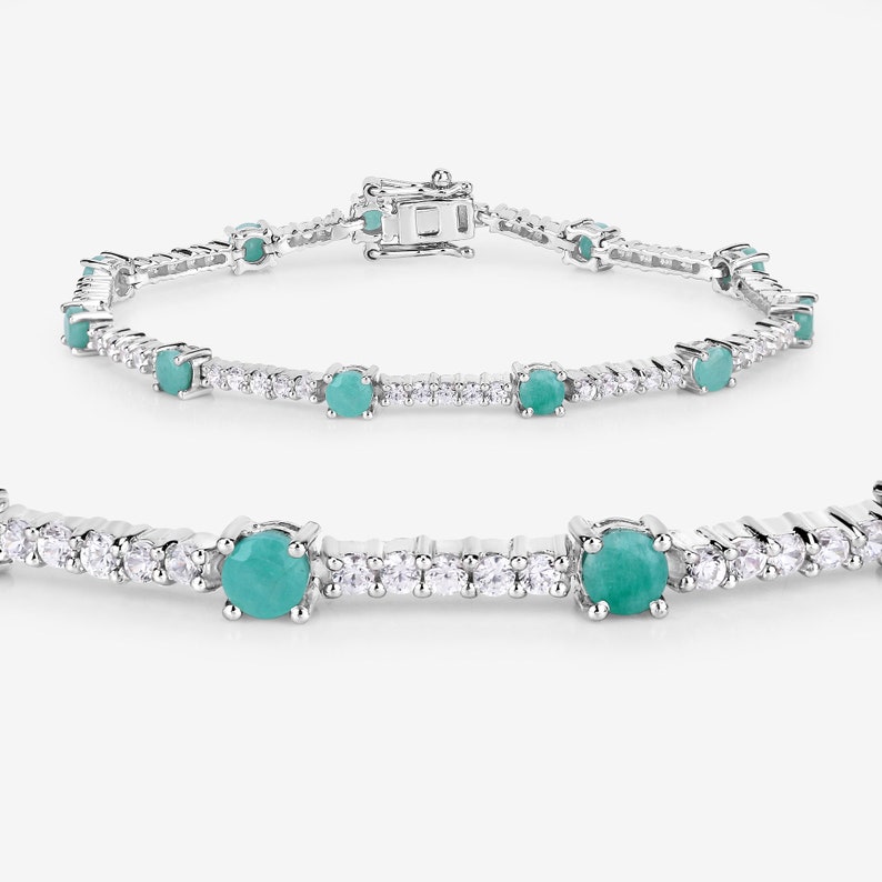 May include: A silver tennis bracelet featuring round turquoise gemstones and smaller clear gemstones.