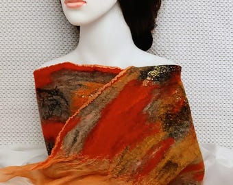 May include: A vibrant, handmade scarf in shades of orange, red, brown, and gold. The scarf is draped over a mannequin, showcasing its unique, artistic design. The scarf's texture appears soft and flowing, with a blend of colors and patterns.