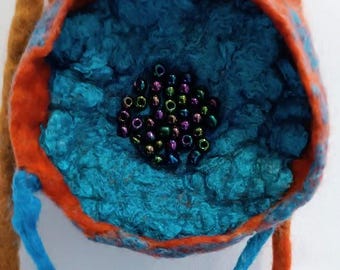 May include: A small, round, felted pouch with a blue interior and an orange rim. The pouch has a blue drawstring and is decorated with iridescent beads.