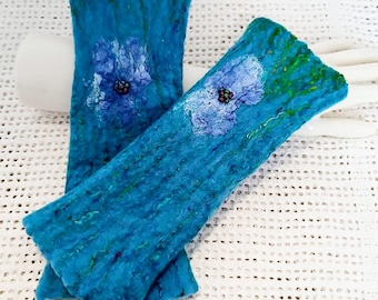 Könnte beinhalten: Ein Paar tealblaue, filzgefütterte Fingerlose Handschuhe mit gestickten blauen Blumen und grünen Stielen.