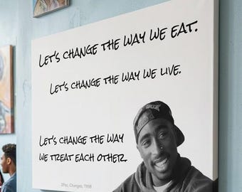 May include: A rectangular canvas wall art piece featuring a black and white portrait of Tupac Shakur and the text: Let's change the way we eat. Let's change the way we live. Let's change the way we treat each other. The canvas measures 48 by 36 inches.
