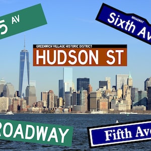 May include: A view of the New York City skyline with various street signs, including "5 Av", "Sixth Ave", "Hudson St", "Broadway", and "Fifth Ave".