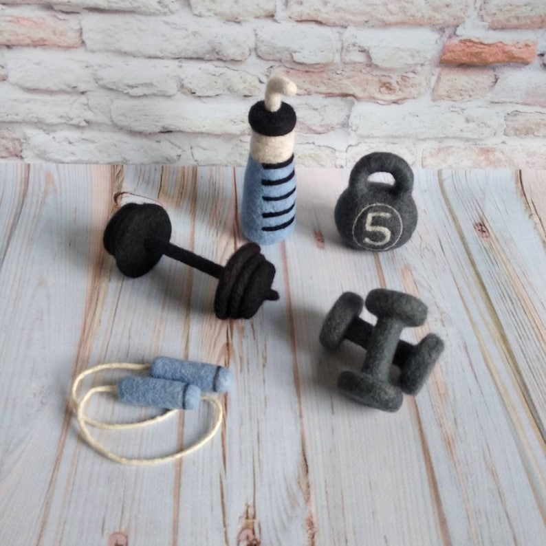 May include: A set of felt gym equipment including a dumbbell, kettlebell, jump rope, and two water bottles. The kettlebell is labeled with the number "5".