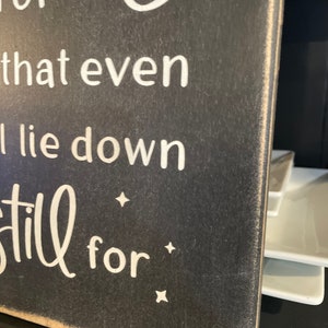 Op de afbeelding: Een zwart houten bord met witte tekst die luidt: "So good that even the stars lie down and be still for..."