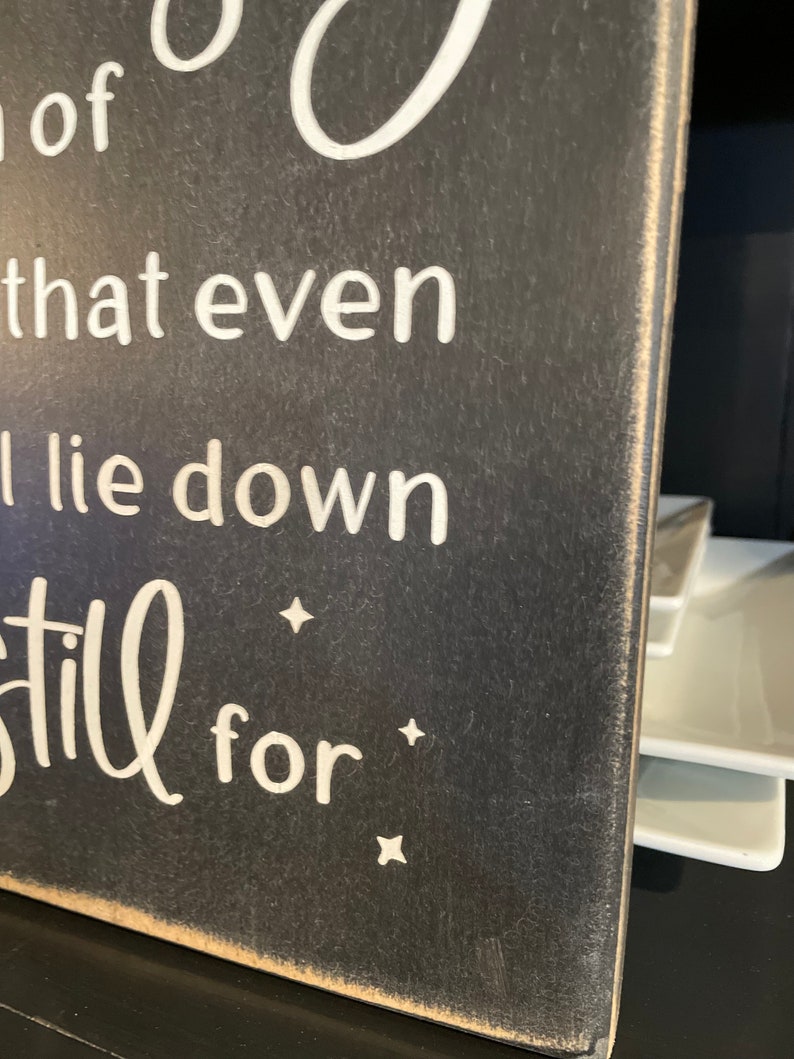Op de afbeelding: Een zwart houten bord met witte tekst die luidt: "So good that even the stars lie down and be still for..."
