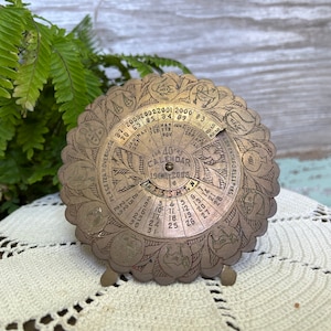 Vintage 40 year brass calendar 19 69–2008 1960s perpetual calendar/MCM/desk ornate brass calendar easel stand with great graphics.
