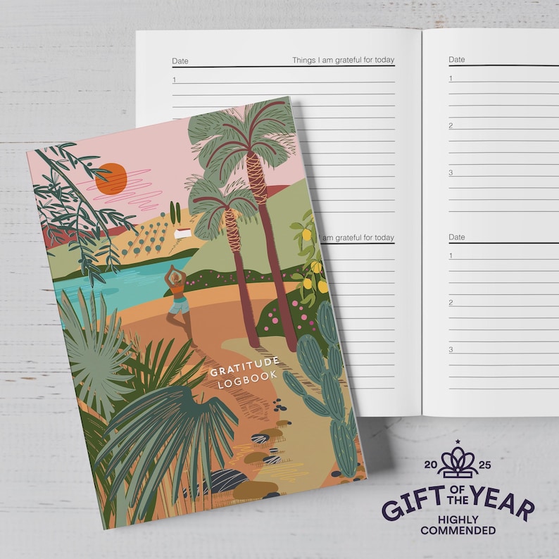 Puede incluir: Un diario de gratitud con una colorida portada que representa una escena tropical con palmeras y una persona haciendo yoga. El libro abierto muestra p&aacute;ginas rayadas para entradas diarias. La portada dice "GRATITUDE LOGBOOK".