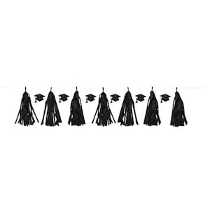 May include: A graduation party banner featuring black tassels and miniature graduation caps. The tassels are long and flowing, and the caps are square with a small tassel. The banner is strung on a thin white string, perfect for a graduation celebration.