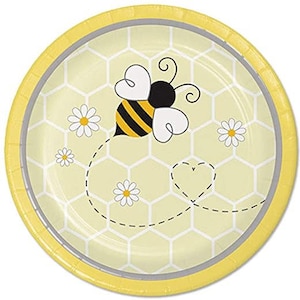 May include: A round paper plate with a yellow and white honeycomb pattern background. A cartoon bee with black and yellow stripes and white wings is in the center. White daisies and a dotted line with a heart complete the design.