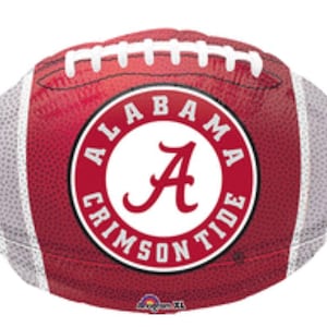 May include: A maroon football-shaped balloon with white stripes and stitching. The center features a circular emblem with the words "ALABAMA CRIMSON TIDE" around a large letter "A".