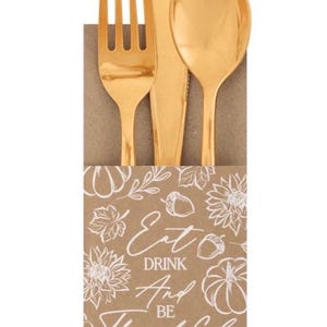 May include: A set of shiny gold-toned plastic cutlery including a fork, knife, and spoon, tucked into a brown paper sleeve. The sleeve features a white line-art print of pumpkins, leaves, and acorns with the text Eat DRINK And BE Thankful.