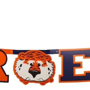 May include: A banner with the words "WAR EAGLE" in orange and navy blue block letters. The banner includes a tiger head and a cartoon tiger figure. The banner is likely for a sports team.