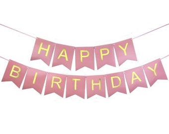 May include: Pink banner with gold lettering spelling "HAPPY BIRTHDAY". The banner is strung on a thin pink string. The pennants are pink with gold letters. Perfect for a birthday celebration.