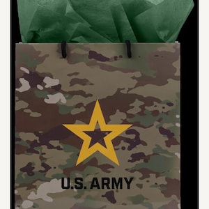 May include: Camouflage-patterned gift bag with a yellow star and the text "U.S. ARMY." The bag is filled with green tissue paper and has black handles. The bag's design features a mix of brown, green, and tan colors.