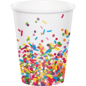 May include: White paper cup decorated with colorful sprinkles in various shapes and sizes. The sprinkles are scattered across the cup, creating a festive and playful design. Perfect for parties and celebrations.
