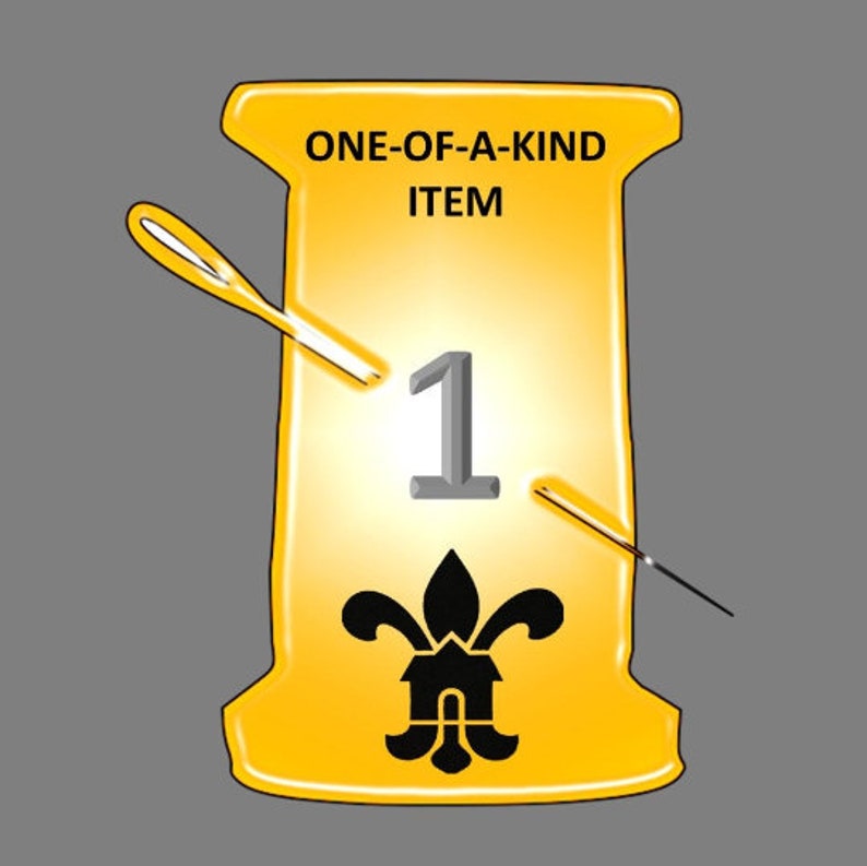 May include: A yellow spool with the text "ONE-OF-A-KIND ITEM" and the number "1" in a grey font. A black fleur-de-lis design is in the centre of the spool. Two needles are crossed over the spool.