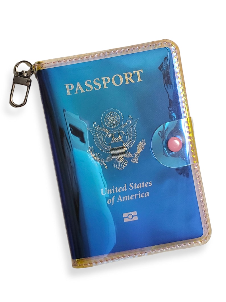 K&ouml;nnte beinhalten: Ein blauer Reisepass-Etui mit einem goldenen Rei&szlig;verschluss und einem transparenten Plastikfenster. Das Etui tr&auml;gt die Aufschrift "PASSPORT" und "United States of America".