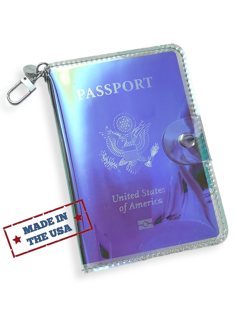 K&ouml;nnte beinhalten: Ein durchsichtiger, schimmernder Reisepass-Etui mit einem silbernen Rei&szlig;verschluss und einem silbernen Verschluss. Das Etui hat ein transparentes Fenster, um einen Reisepass zu pr&auml;sentieren. Der Text "PASSPORT" ist auf der Vorderseite des Etuis aufgedruckt. Der Text "United States of America" ist auf der Vorderseite des Etuis aufgedruckt. Der Text "MADE IN THE USA" ist auf der Seite des Etuis aufgedruckt.