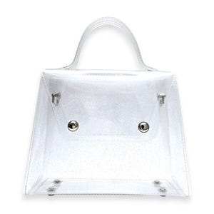 May include: A clear plastic handbag with a silver handle and silver hardware. The bag has a rectangular shape with a slightly angled top.