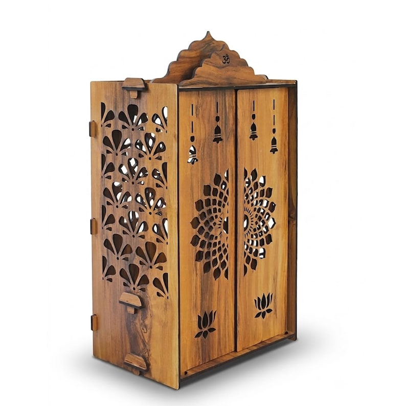 K&ouml;nnte beinhalten: Ein h&ouml;lzerner Tempelschrank mit komplizierten lasergeschnittenen Mustern an den Seiten- und Frontpaneelen. Die Vordert&uuml;ren zeigen ein gro&szlig;es florales Mandala-Design und Lotusmotive, mit einem kleinen Om-Symbol im gew&ouml;lbten oberen Giebel.