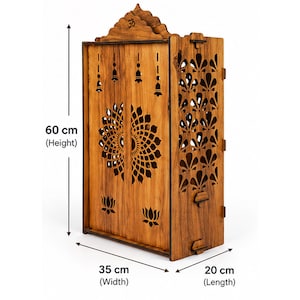 K&ouml;nnte beinhalten: Ein h&ouml;lzerner Heimtempel mit lasergeschnittenen Blumen- und Glockenmustern, einem Om-Symbol an der Spitze und Seitenteilen mit Blattausschnitten. Die Ma&szlig;e sind mit 60 cm H&ouml;he, 35 cm Breite und 20 cm L&auml;nge angegeben.