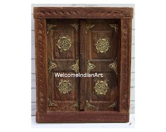 May include: A rectangular brown wooden wall hanging featuring two hinged doors with brass floral accents and corner plates. The text WelcomeIndianArt is printed in white across the center of the wooden surface, which has a visible grain texture.