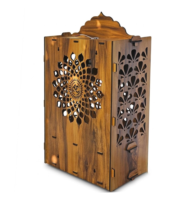 K&ouml;nnte beinhalten: Eine h&ouml;lzerne Tempelstruktur mit dunkelbrauner Holzmaserung. Die Vorderseite zeigt ein lasergeschnittenes Mandalamuster mit einem Om-Symbol in der Mitte. Die Seitenwand hat ein wiederkehrendes florales Ausschnittdesign und der obere Teil ist bogenf&ouml;rmig.