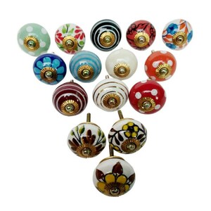 May include: Assortment of 15 ceramic knobs with various patterns and colors, including floral, polka dot, and striped designs. The knobs have a gold-colored metal base.