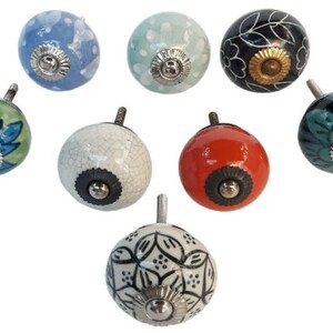 May include: Set of seven ceramic drawer knobs with various floral and geometric patterns. The knobs are in shades of blue, green, white, black, and red.