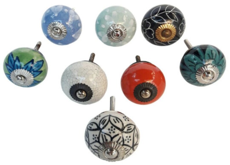 May include: Set of seven ceramic drawer knobs with various floral and geometric patterns. The knobs are in shades of blue, green, white, black, and red.