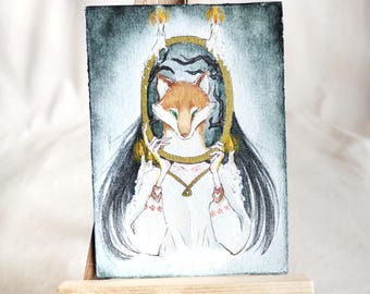 Puede incluir: Pintura acuarela de una mujer con cabello negro largo sosteniendo un espejo dorado con un rostro de zorro en su interior. El espejo está rodeado por dos velas encendidas. El fondo es gris oscuro.