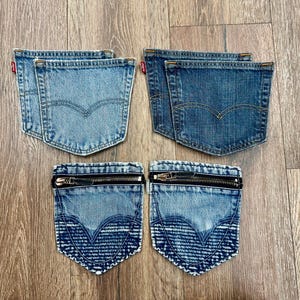 May include: Six denim pockets in various blue washes. Two light blue pockets and two medium blue pockets feature the signature Levi's arcuate stitching and red tabs. Two additional pockets have a dark blue wash, zippers, and textured patterns.